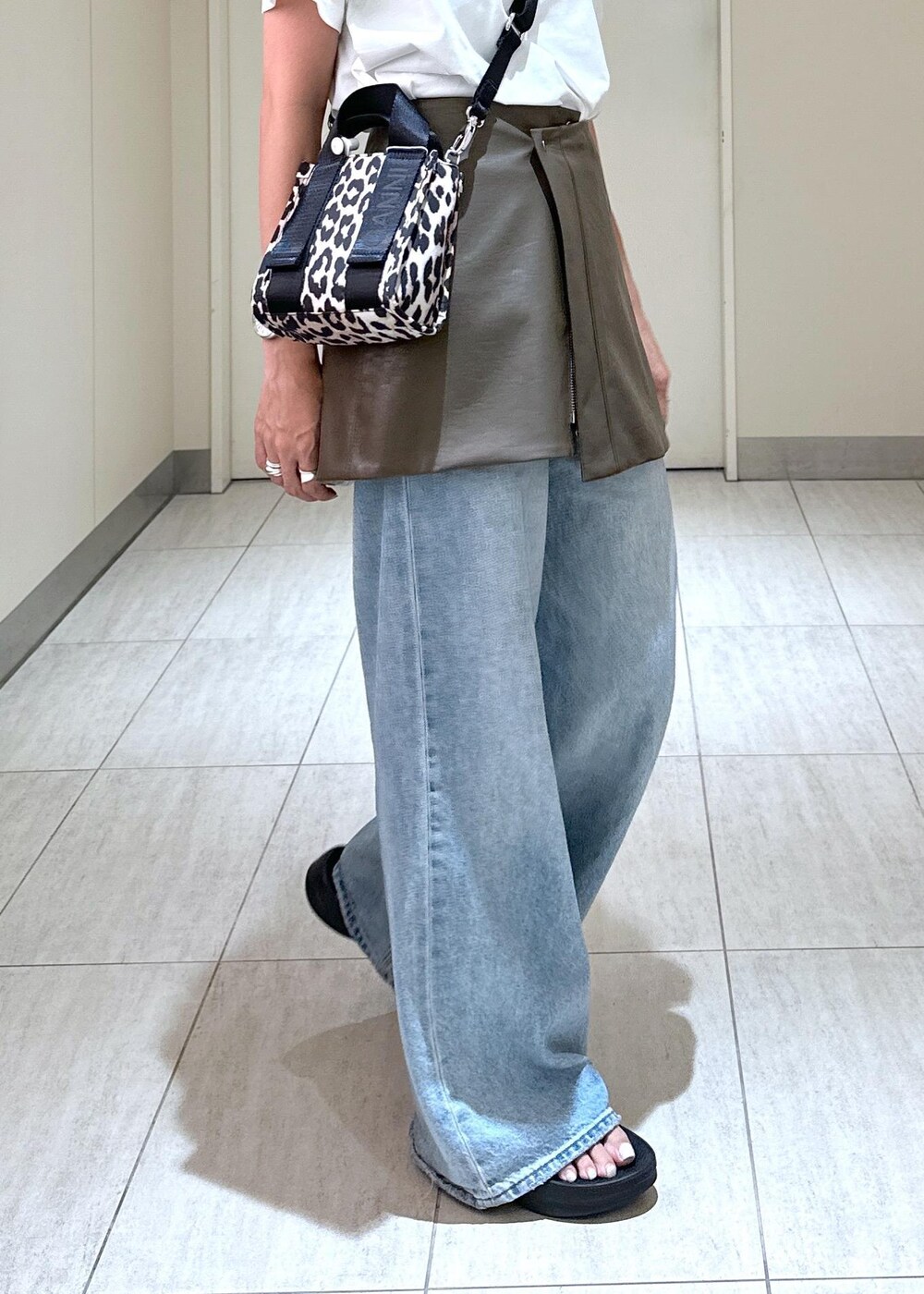 ベージュ系のトートバッグ、ブラウン系のスカート、ホワイト系のTシャツ/カットソーを着用したレディースの夏コーディネートの8枚目の写真