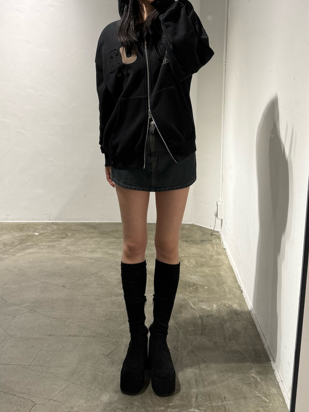 ブラック系のパーカー、ブラック系のブーツを着用したレディースの冬コーディネートの3枚目の写真