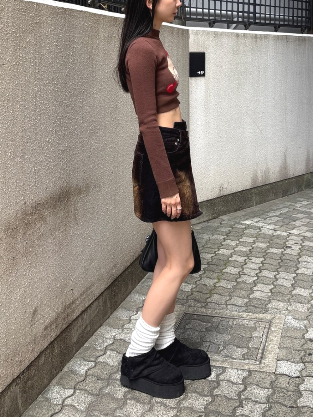 ブラウン系のスカート、ブラック系のスリッポン、ブラウン系のニット/セーターを着用したレディースの夏コーディネートの4枚目の写真