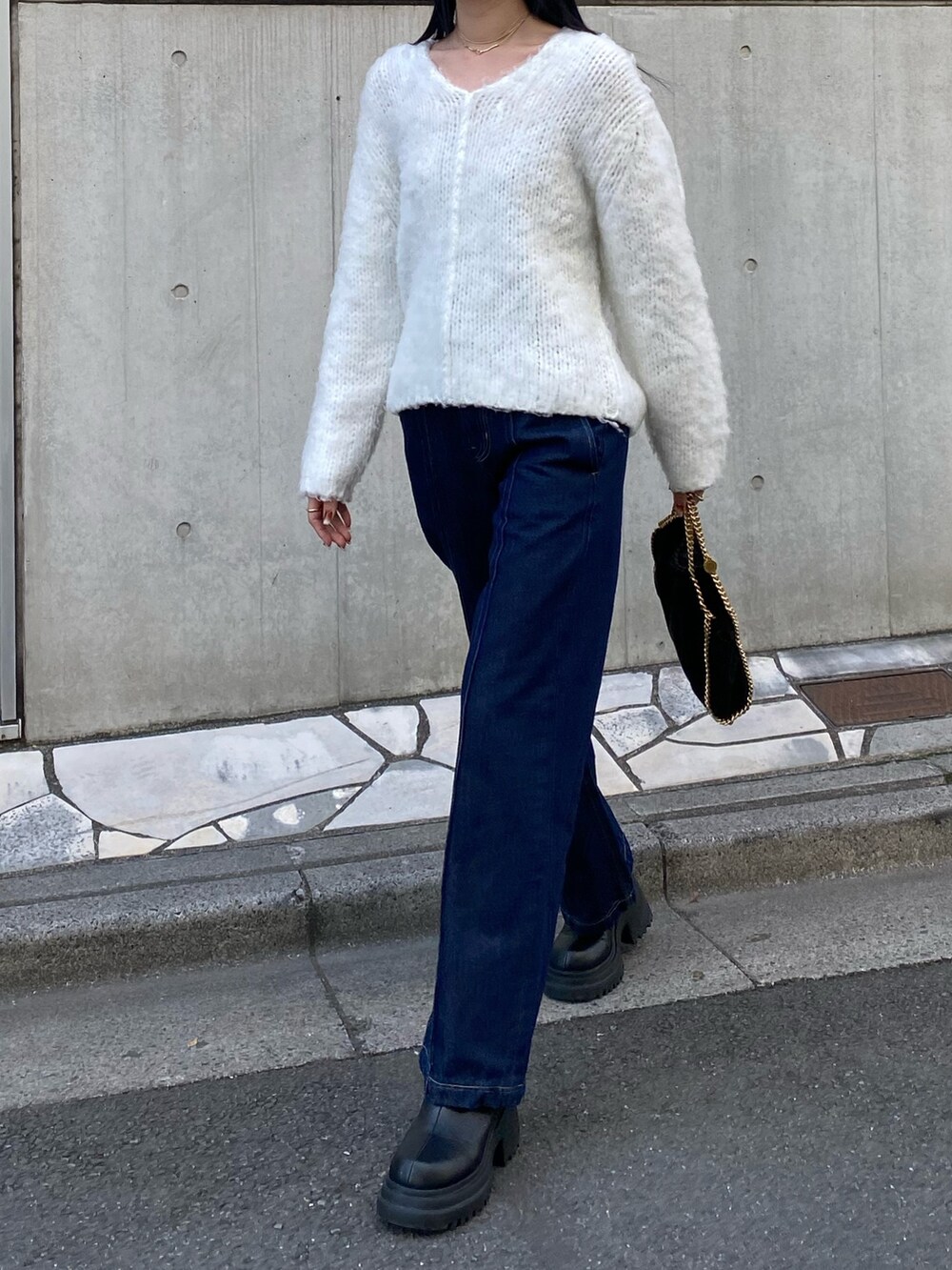 ホワイト系のニット/セーター、ブルー系のデニムパンツ、ブラック系のブーツを着用したレディースの冬コーディネートの4枚目の写真