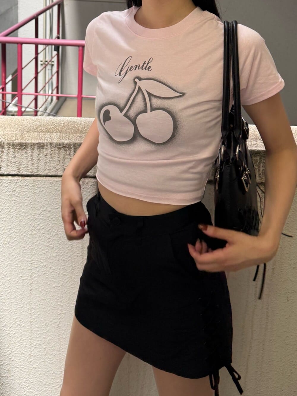 ブラック系のサンダル、ブラック系のショルダーバッグ、ピンク系のTシャツ/カットソーを着用したレディースの夏コーディネートの5枚目の写真