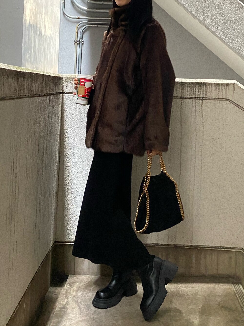 ブラウン系のその他アウター、ブラック系のワンピースを着用したレディースの冬コーディネートの2枚目の写真