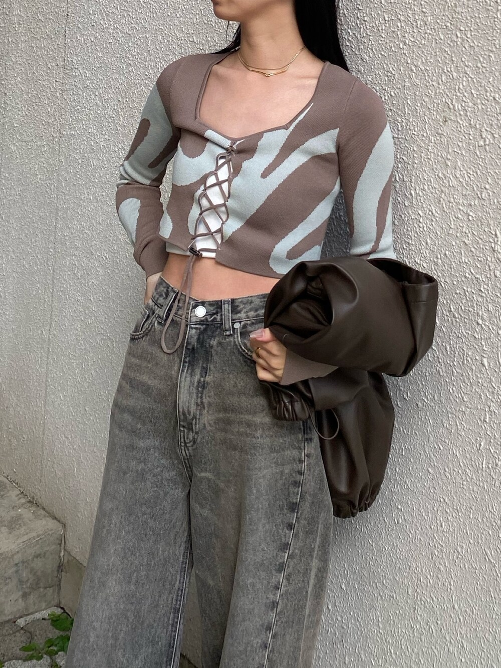 ブラウン系のニット/セーターを着用したレディースの春コーディネートの2枚目の写真