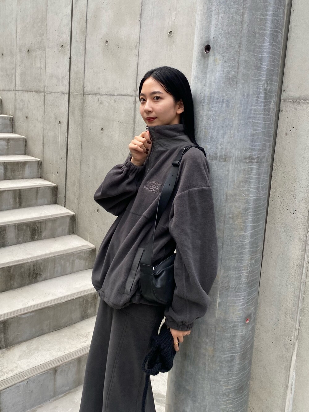 グレー系のスカート、ブラック系のショルダーバッグ、グレー系のTシャツ/カットソーを着用したレディースの秋コーディネートの4枚目の写真