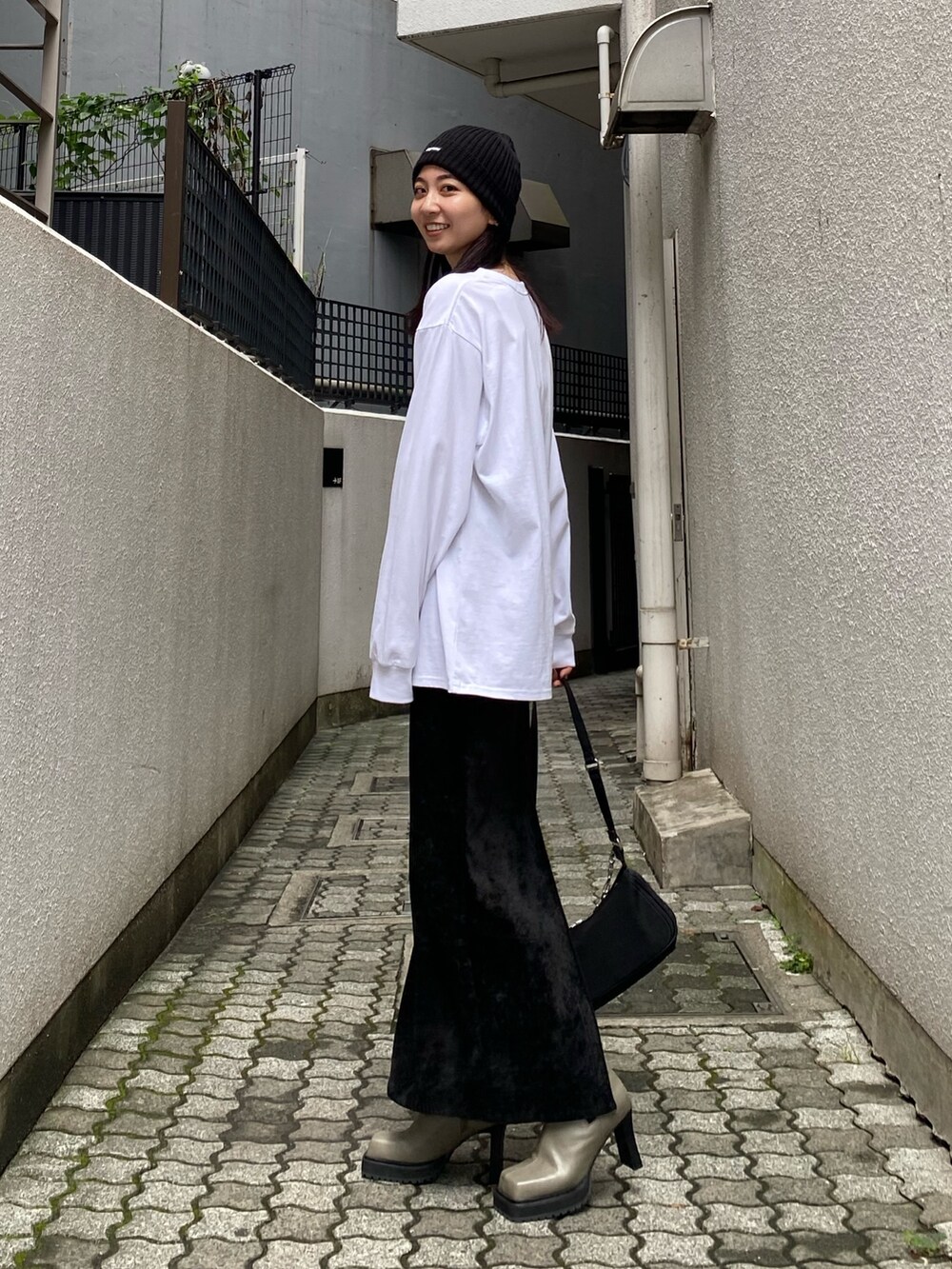 ホワイト系のTシャツ/カットソー、ブラック系のスカート、グレー系のブーツを着用したレディースの秋コーディネートの2枚目の写真