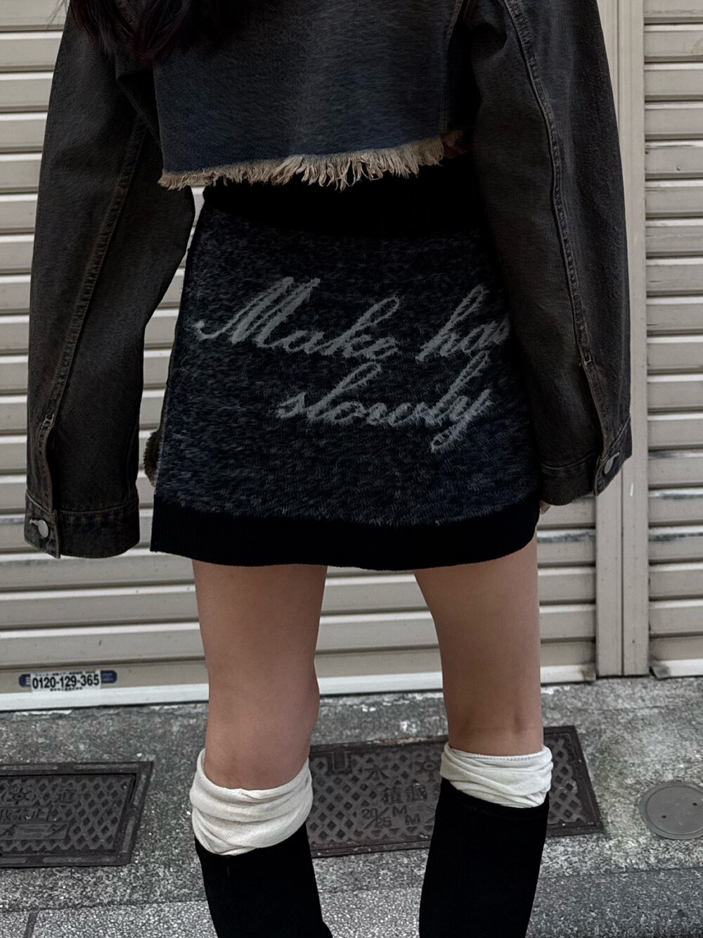 ブラック系のブーツ、ブルー系のスカート、ブルー系のデニムジャケットを着用したレディースの夏コーディネートの4枚目の写真