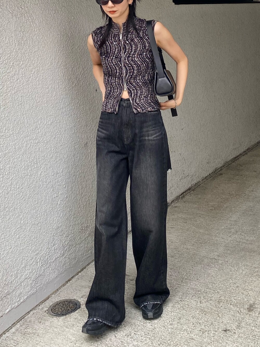 ブラック系のデニムパンツ、ブラウン系のタンクトップを着用したレディースの夏コーディネートの2枚目の写真