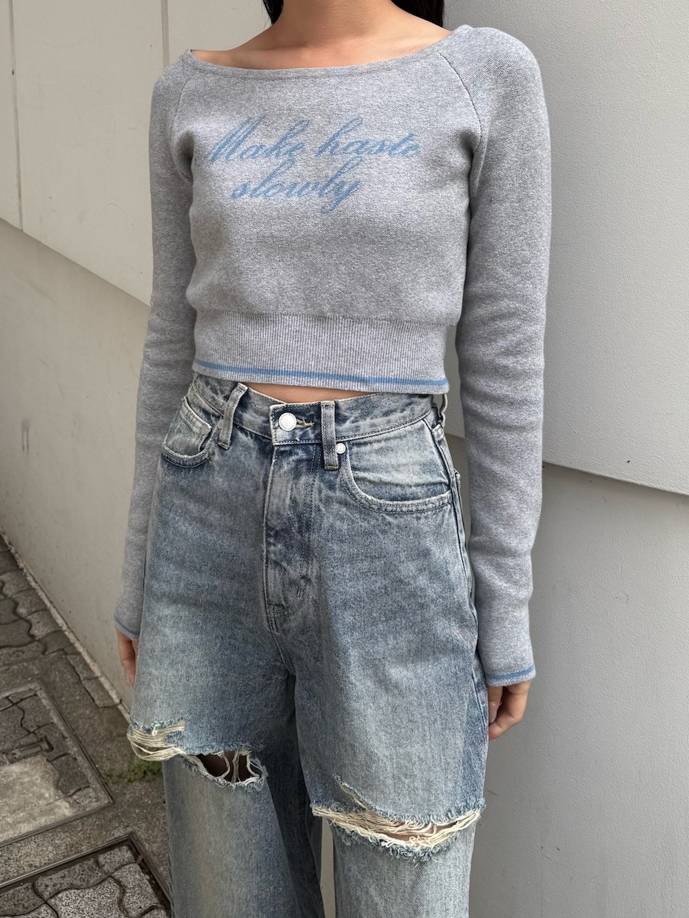 グレー系のニット/セーター、ブルー系のデニムパンツ、ブラック系のスニーカーを着用したレディースの秋コーディネートの3枚目の写真