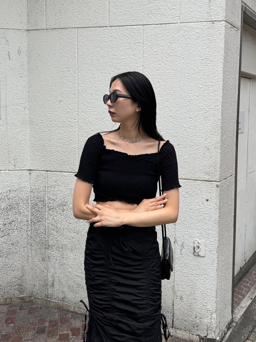 ブラック系のサンダル、ブラック系のスカート、ブラック系のTシャツ/カットソーを着用したレディースの夏コーディネートの4枚目の写真