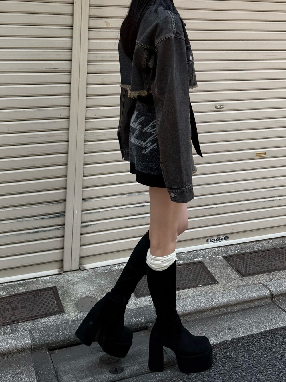 ブラック系のブーツ、ブルー系のスカート、ブルー系のデニムジャケットを着用したレディースの夏コーディネートの2枚目の写真