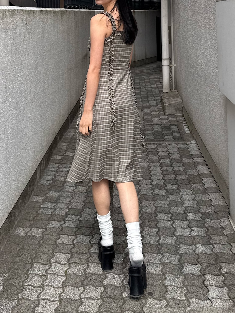 ベージュ系のワンピース、ブラック系のサンダルを着用したレディースの春コーディネートの2枚目の写真