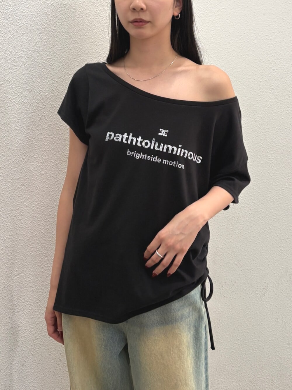 ブルー系のデニムパンツ、ブラック系のハンドバッグ、ブラック系のTシャツ/カットソーを着用したレディースの夏コーディネートの4枚目の写真