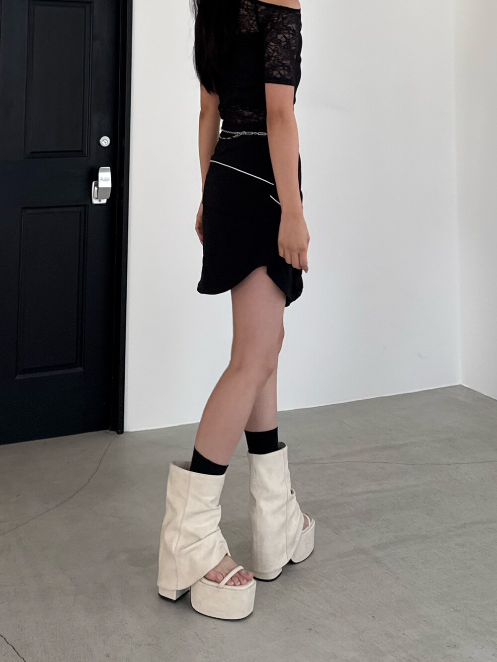 ホワイト系のサンダル、ブラック系のスカート、ブラック系のTシャツ/カットソーを着用したレディースの夏コーディネートの3枚目の写真