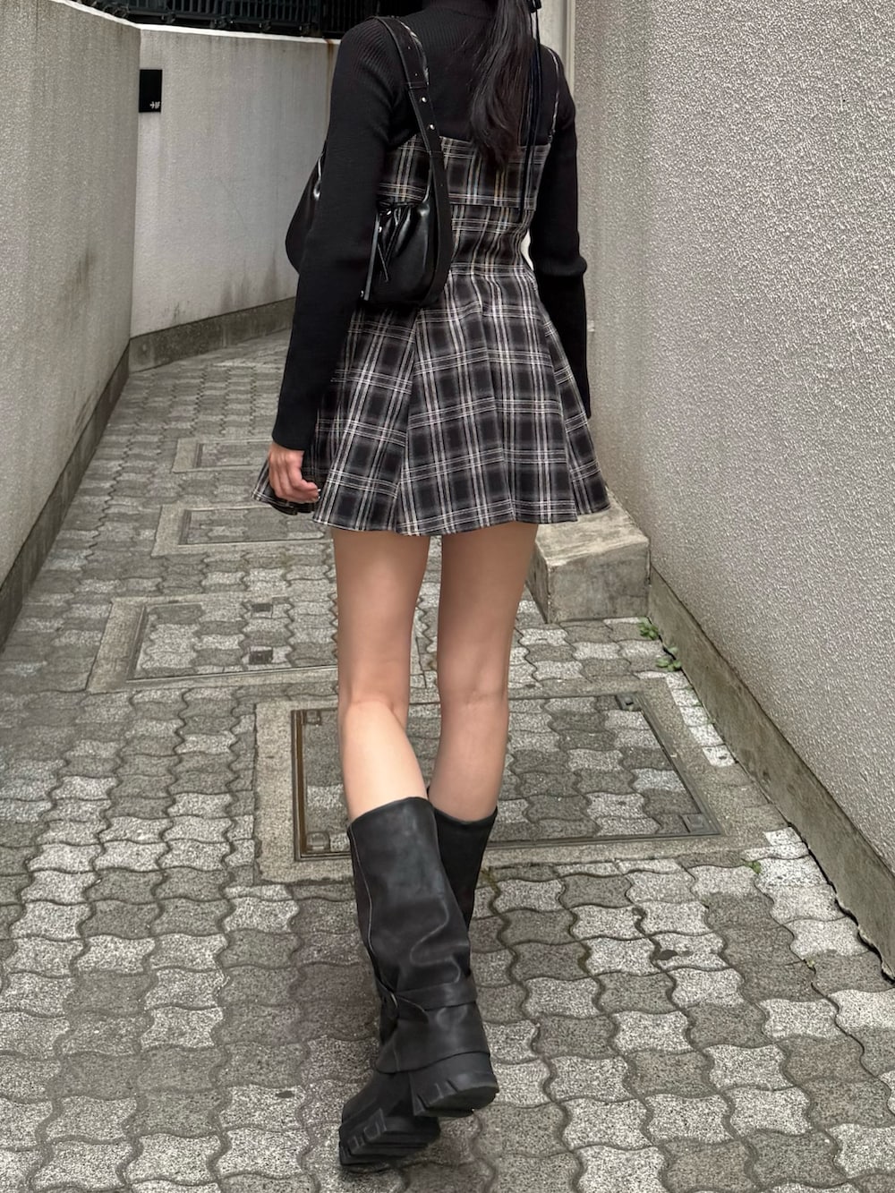 ブラック系のワンピース、ブラック系のブーツを着用したレディースの冬コーディネートの3枚目の写真