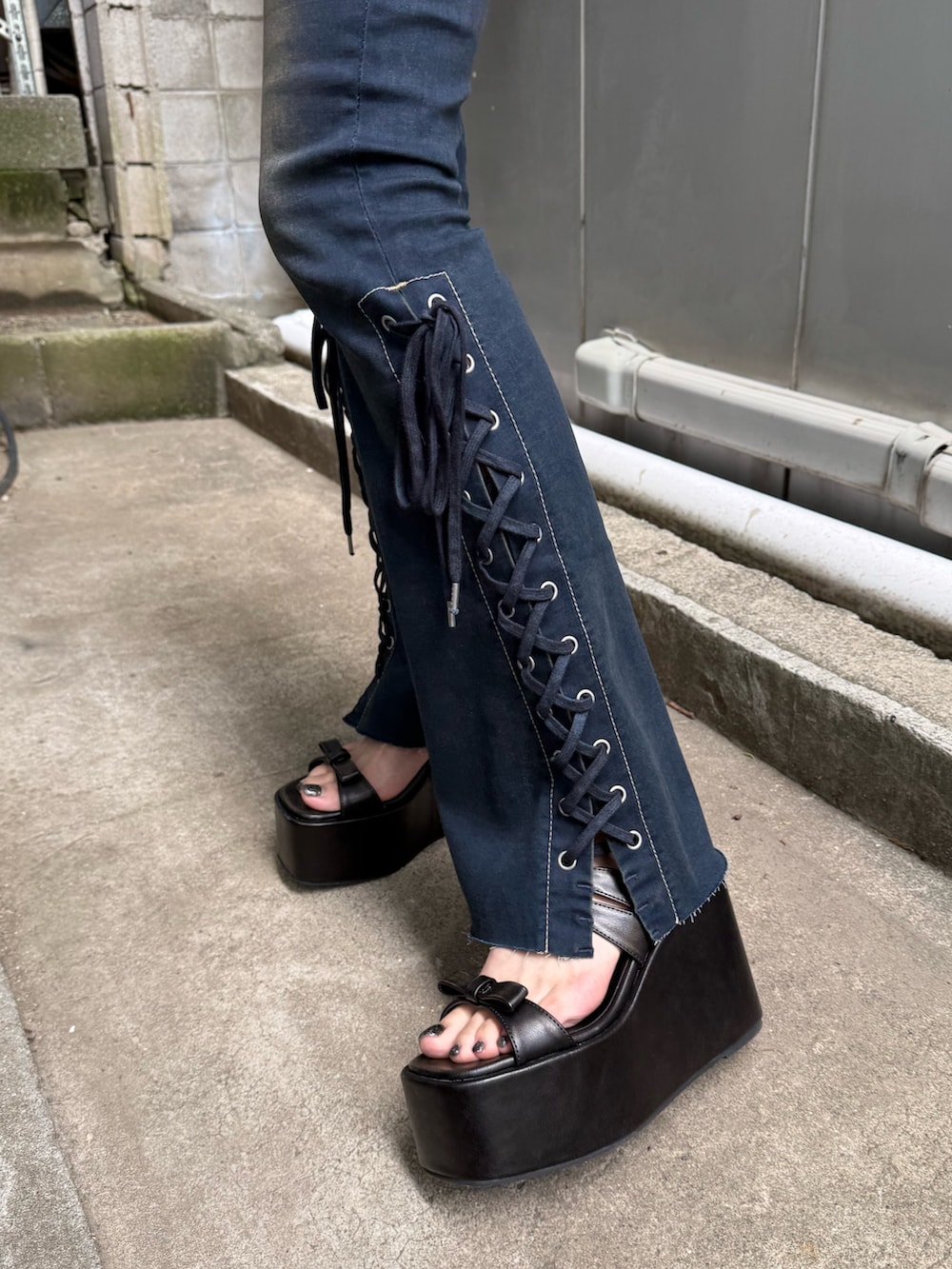 ブラック系のサンダル、ブルー系のデニムパンツ、ブラック系のTシャツ/カットソーを着用したレディースの夏コーディネートの6枚目の写真