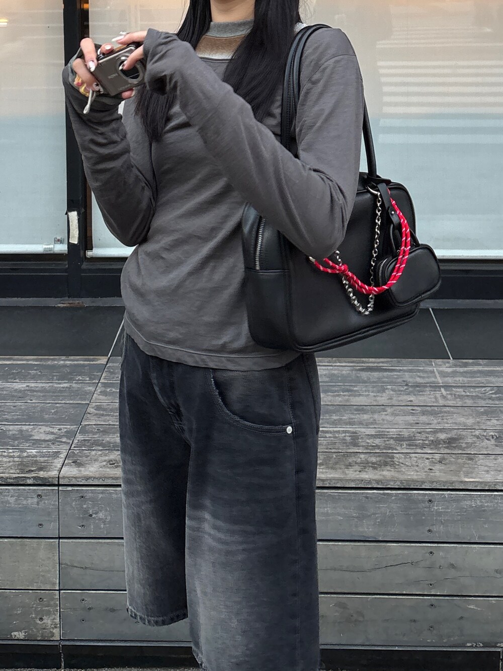 グレー系のTシャツ/カットソー、ブラック系のデニムパンツ、ブラック系のハンドバッグを着用したレディースの冬コーディネートの2枚目の写真