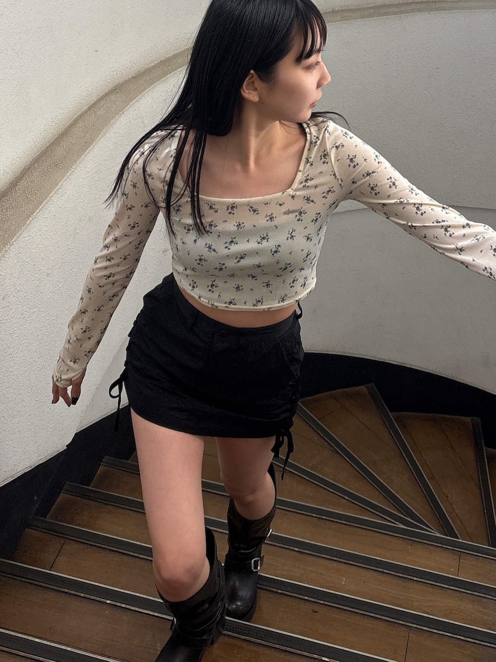 ブラック系のブーツ、ホワイト系のTシャツ/カットソー、ブラック系のスカートを着用したレディースの春コーディネートの2枚目の写真