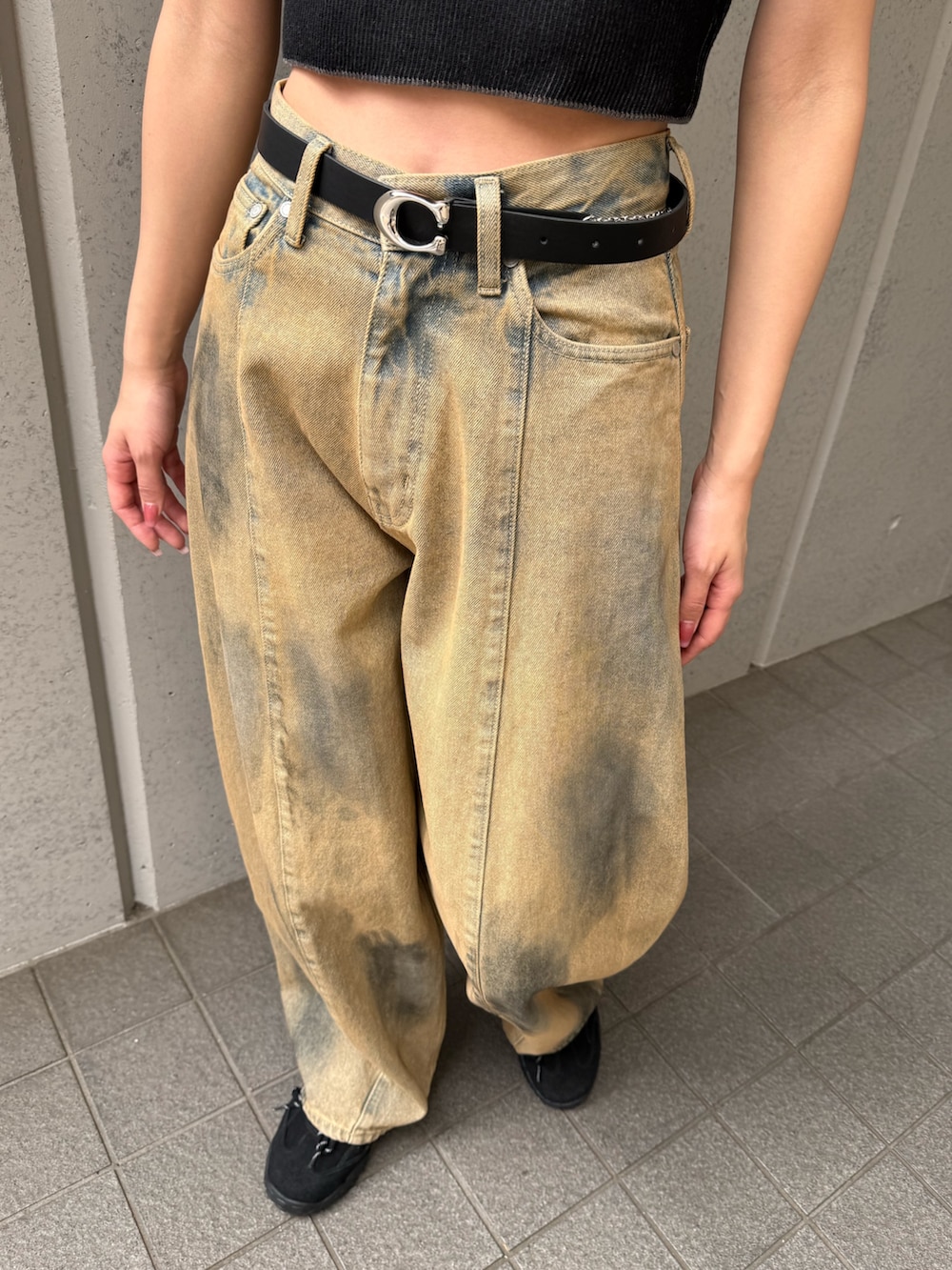 ベージュ系のデニムパンツ、ブラック系のニット/セーター、ブラック系のスニーカーを着用したレディースの夏コーディネートの2枚目の写真