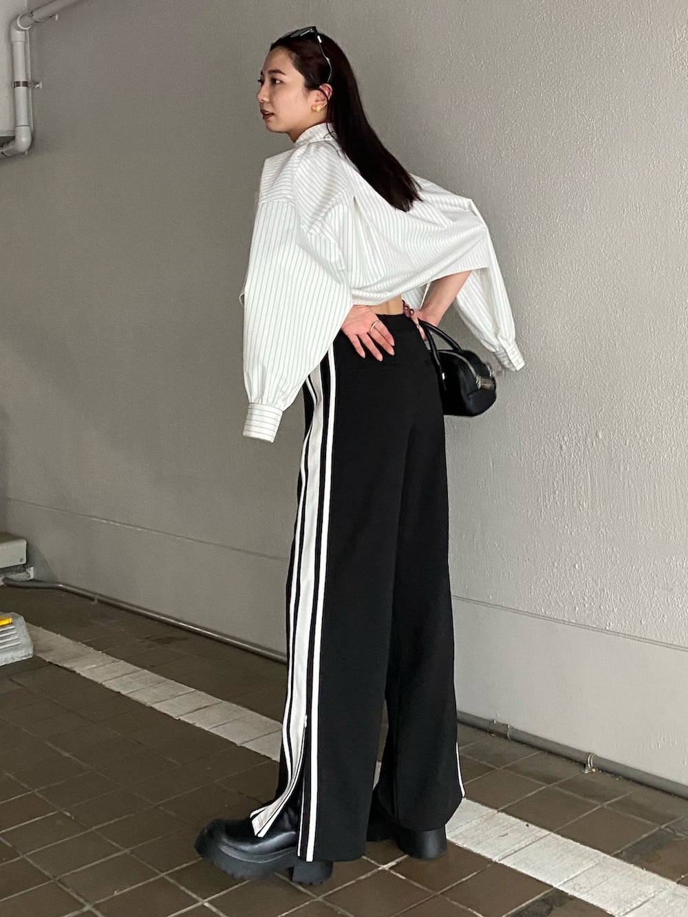 その他のシャツ/ブラウス、ブラック系のブーツ、ブラック系のハンドバッグを着用したレディースの夏コーディネートの2枚目の写真