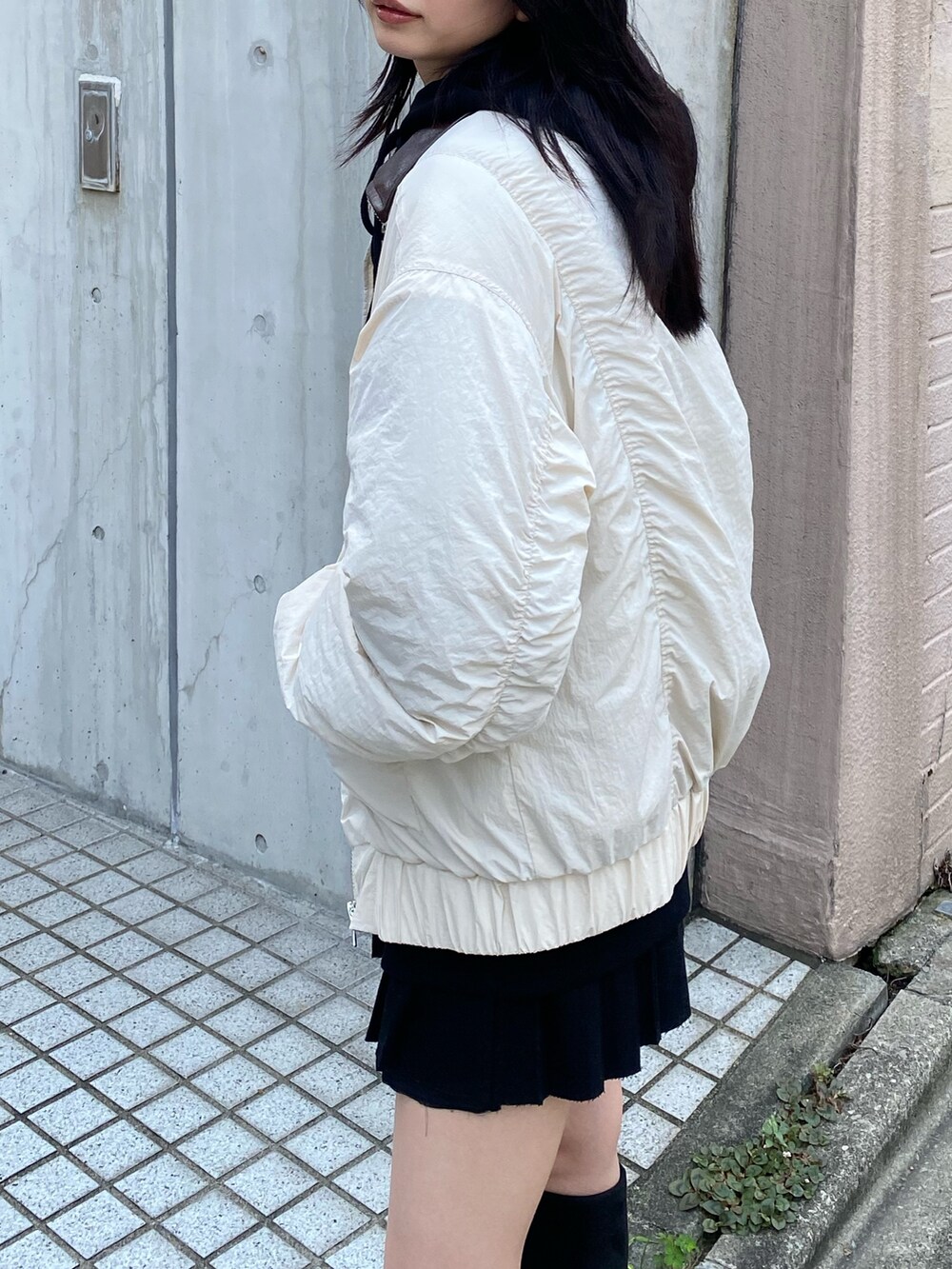 グレー系のブルゾン、ブラック系のパーカー、ブラック系のブーツを着用したレディースの夏コーディネートの3枚目の写真