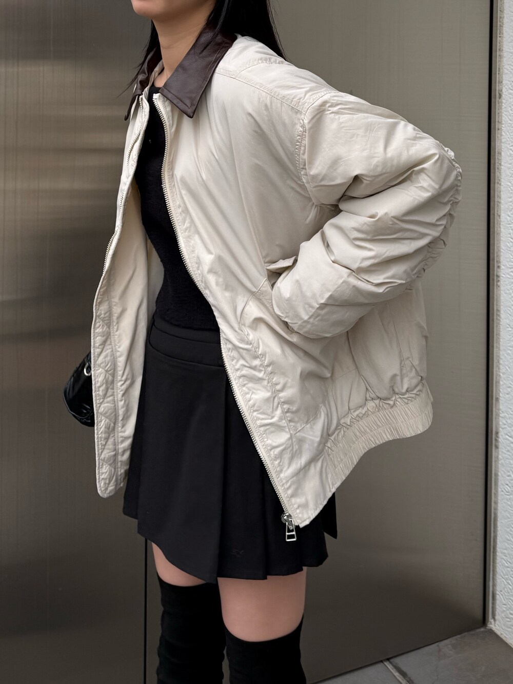 ブラック系のブーツ、ホワイト系のブルゾンを着用したレディースの冬コーディネートの3枚目の写真