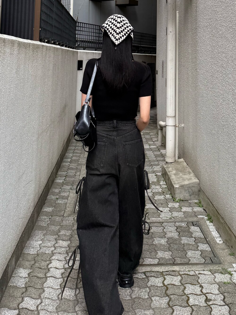 ブラック系のデニムパンツ、ブラック系のニット/セーターを着用したレディースの夏コーディネートの3枚目の写真