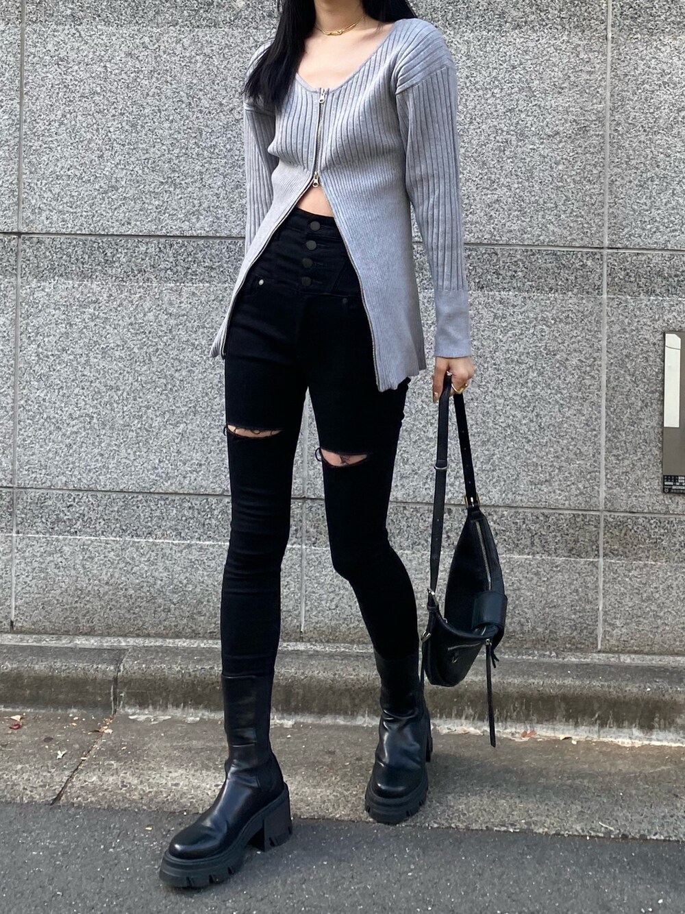 ブラック系のデニムパンツ、グレー系のニット/セーター、ブラック系のブーツを着用したレディースの冬コーディネートの3枚目の写真