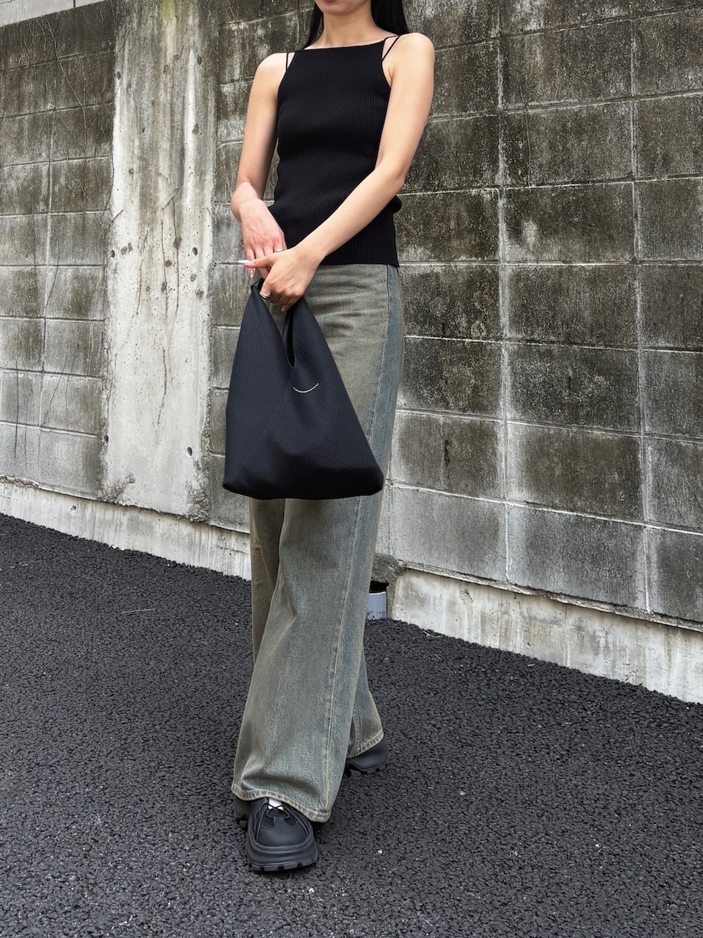 ブルー系のデニムパンツ、ブラック系のキャミソール、ブラック系のサンダルを着用したレディースの春コーディネートの2枚目の写真