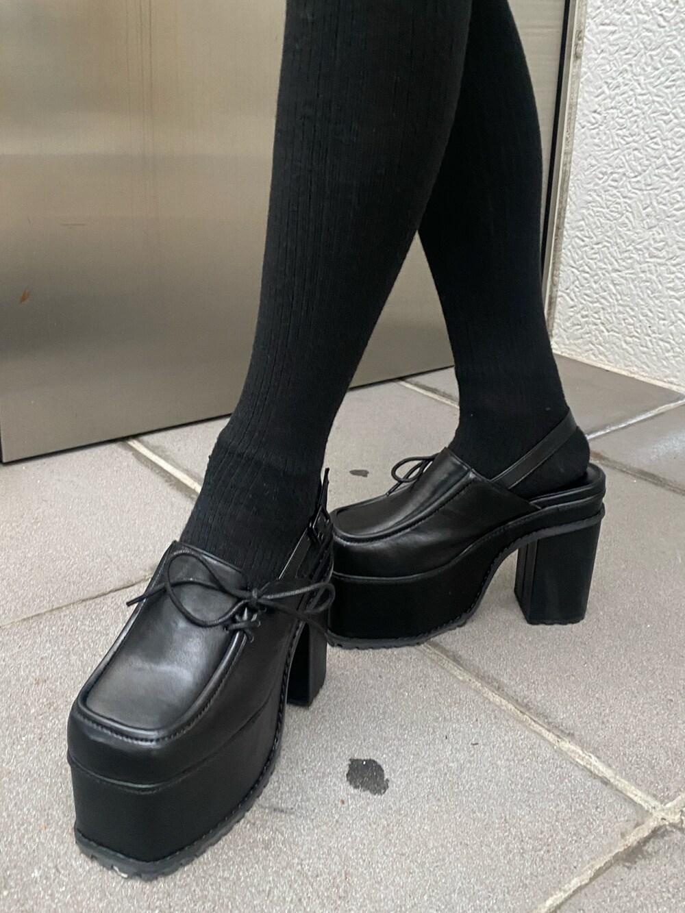 グレー系のワンピース、ブラック系のニット/セーター、ブラック系のサンダルを着用したレディースの秋コーディネートの3枚目の写真