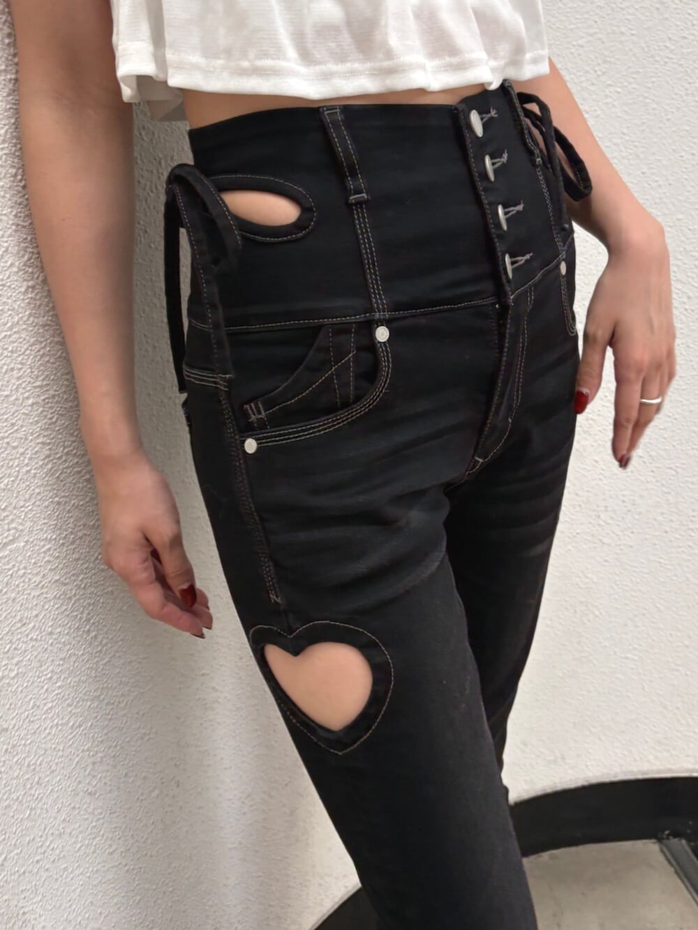 ブラック系のハンドバッグ、ブラック系のデニムパンツ、ホワイト系のタンクトップを着用したレディースの夏コーディネートの8枚目の写真