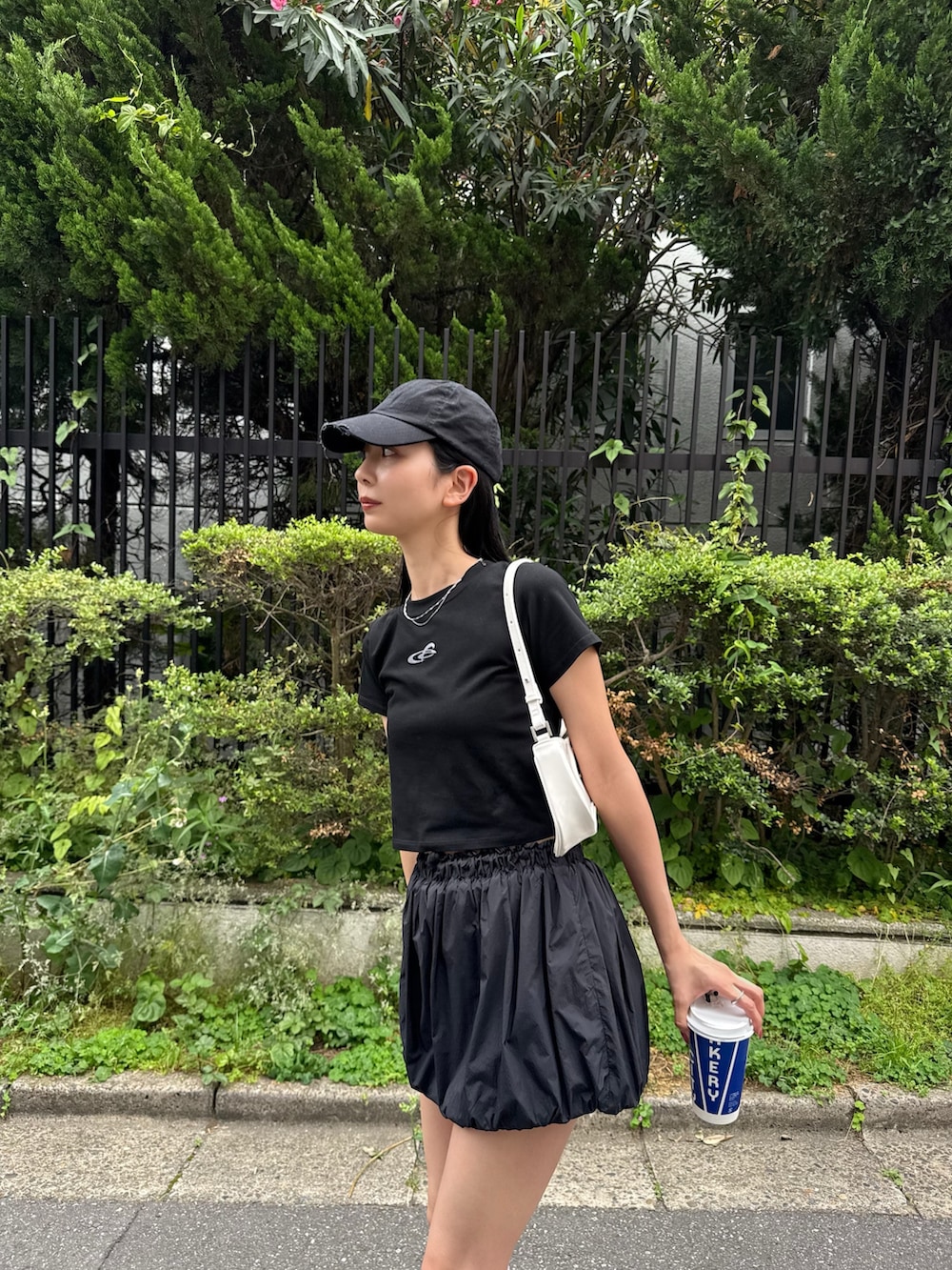 ブラック系のスカート、ブラック系のTシャツ/カットソー、ブラック系のサンダルを着用したレディースの春コーディネートの2枚目の写真