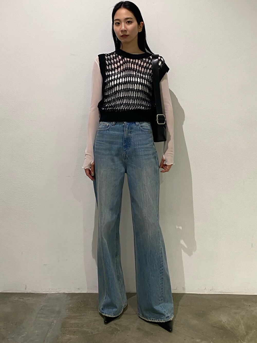 ブルー系のデニムパンツ、ブラック系のタンクトップ、ホワイト系のTシャツ/カットソーを着用したレディースの春コーディネートの4枚目の写真