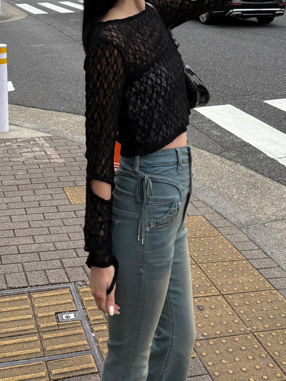 ブルー系のデニムパンツ、ブラック系のTシャツ/カットソー、ブラック系のパンプスを着用したレディースの春コーディネートの3枚目の写真