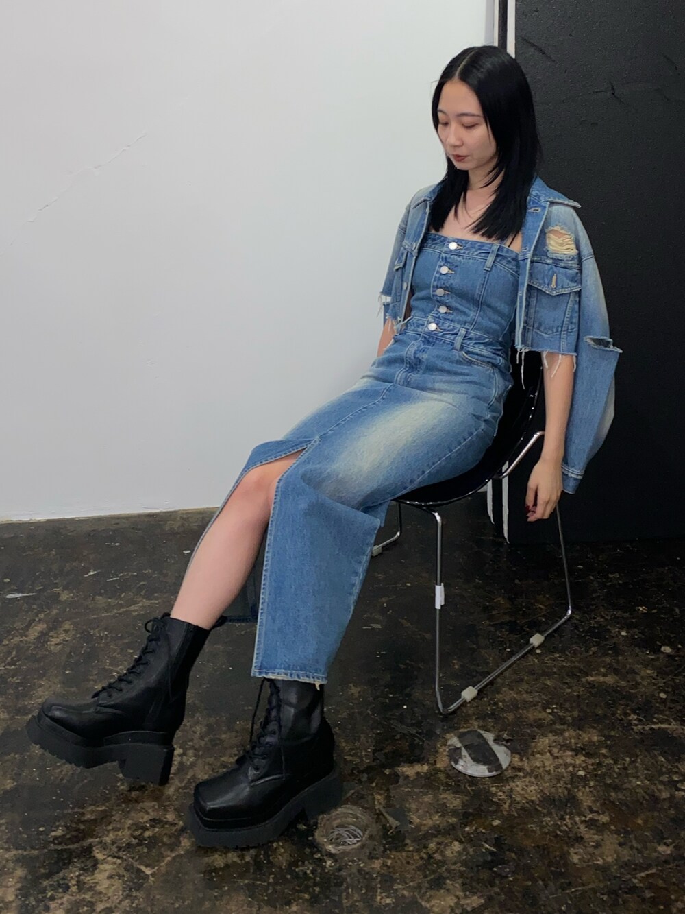 ブルー系のワンピース、ブルー系のデニムジャケット、ブラック系のブーツを着用したレディースの春コーディネートの3枚目の写真