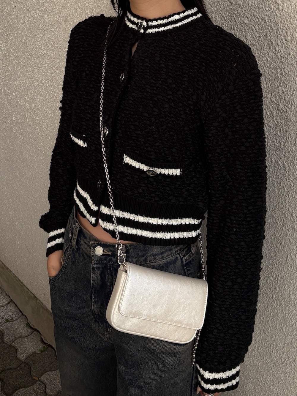 ブルー系のデニムパンツ、ブラック系のカーディガン/ボレロを着用したレディースの冬コーディネートの3枚目の写真