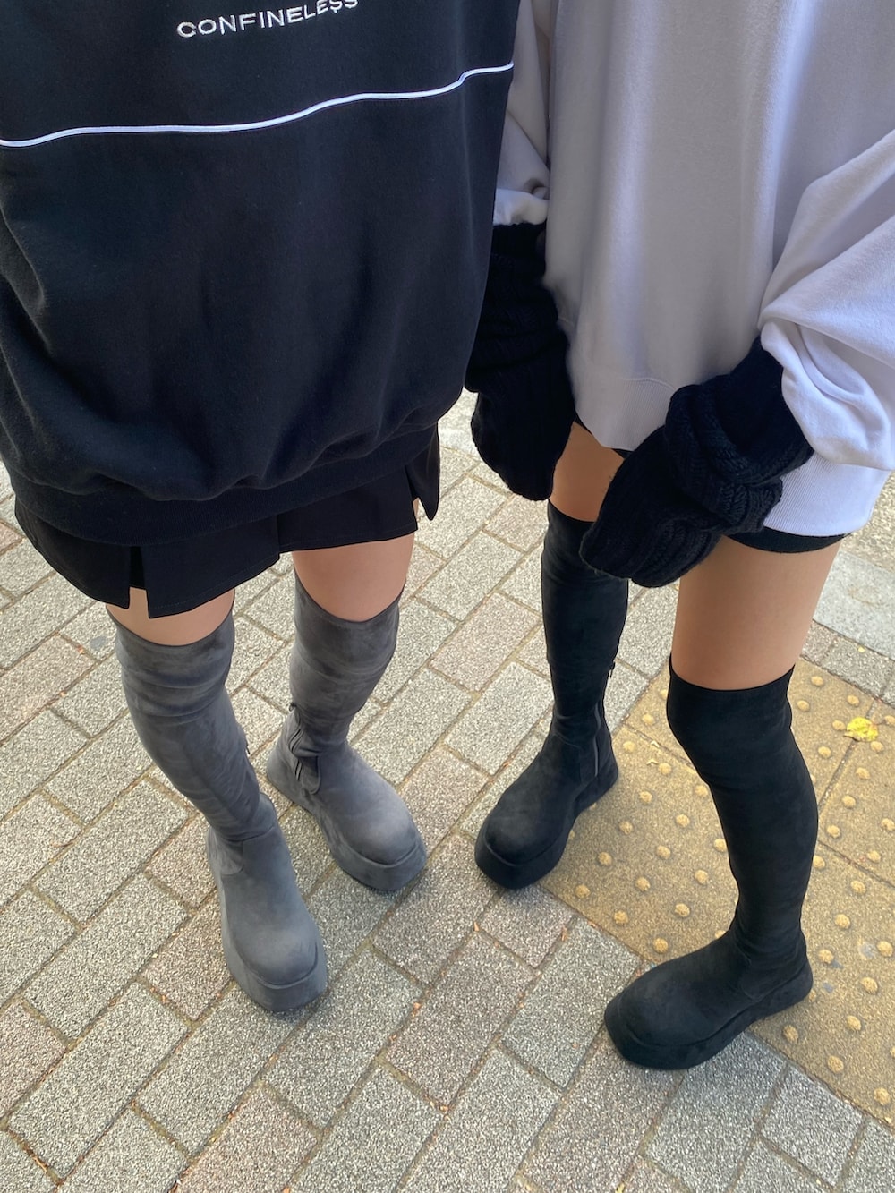 グレー系のブーツ、ブラック系のスウェット、ブラック系のスカートを着用したレディースの夏コーディネートの4枚目の写真