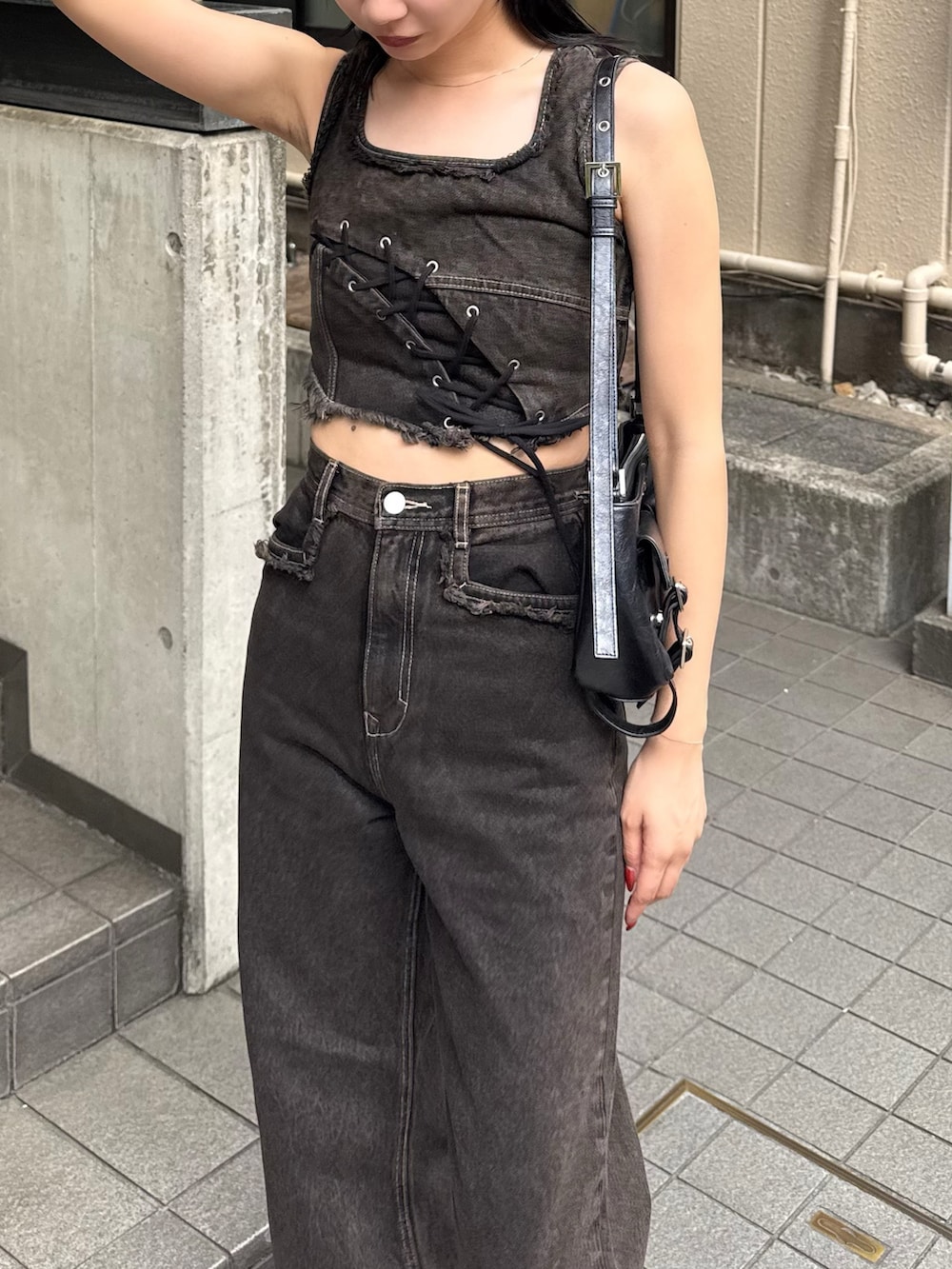 ブラック系のデニムパンツ、ブラック系のタンクトップ、ブラック系のサンダルを着用したレディースの夏コーディネートの3枚目の写真