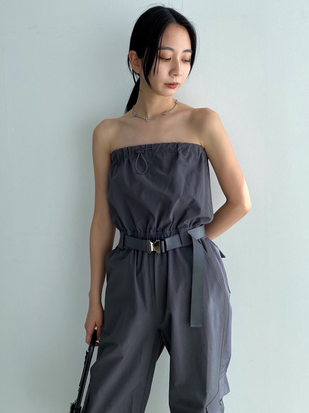 グレー系のつなぎ/オールインワン、ホワイト系のタンクトップ、ブラック系のハンドバッグを着用したレディースの夏コーディネートの3枚目の写真