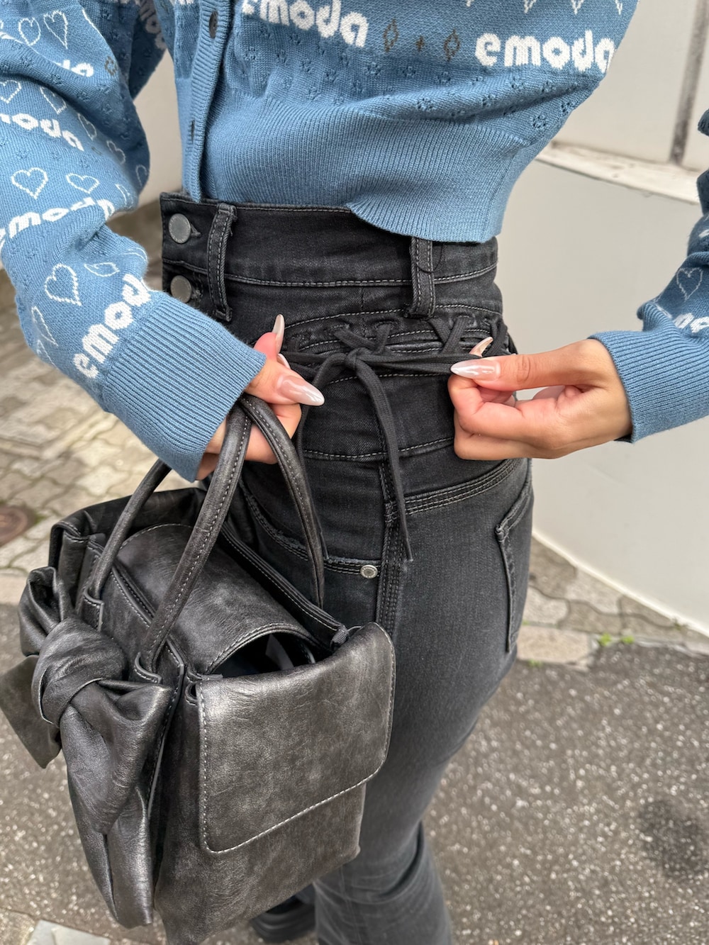 ブルー系のニット/セーター、ブラック系のデニムパンツ、ブラック系のローファーを着用したレディースの冬コーディネートの3枚目の写真