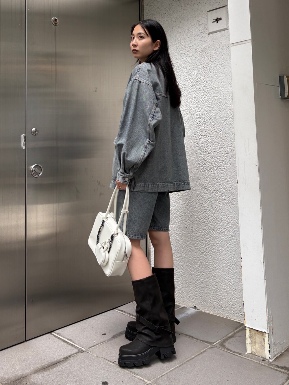 ブルー系のブルゾン、ブルー系のデニムパンツ、ブラウン系のブーツを着用したレディースの冬コーディネートの2枚目の写真