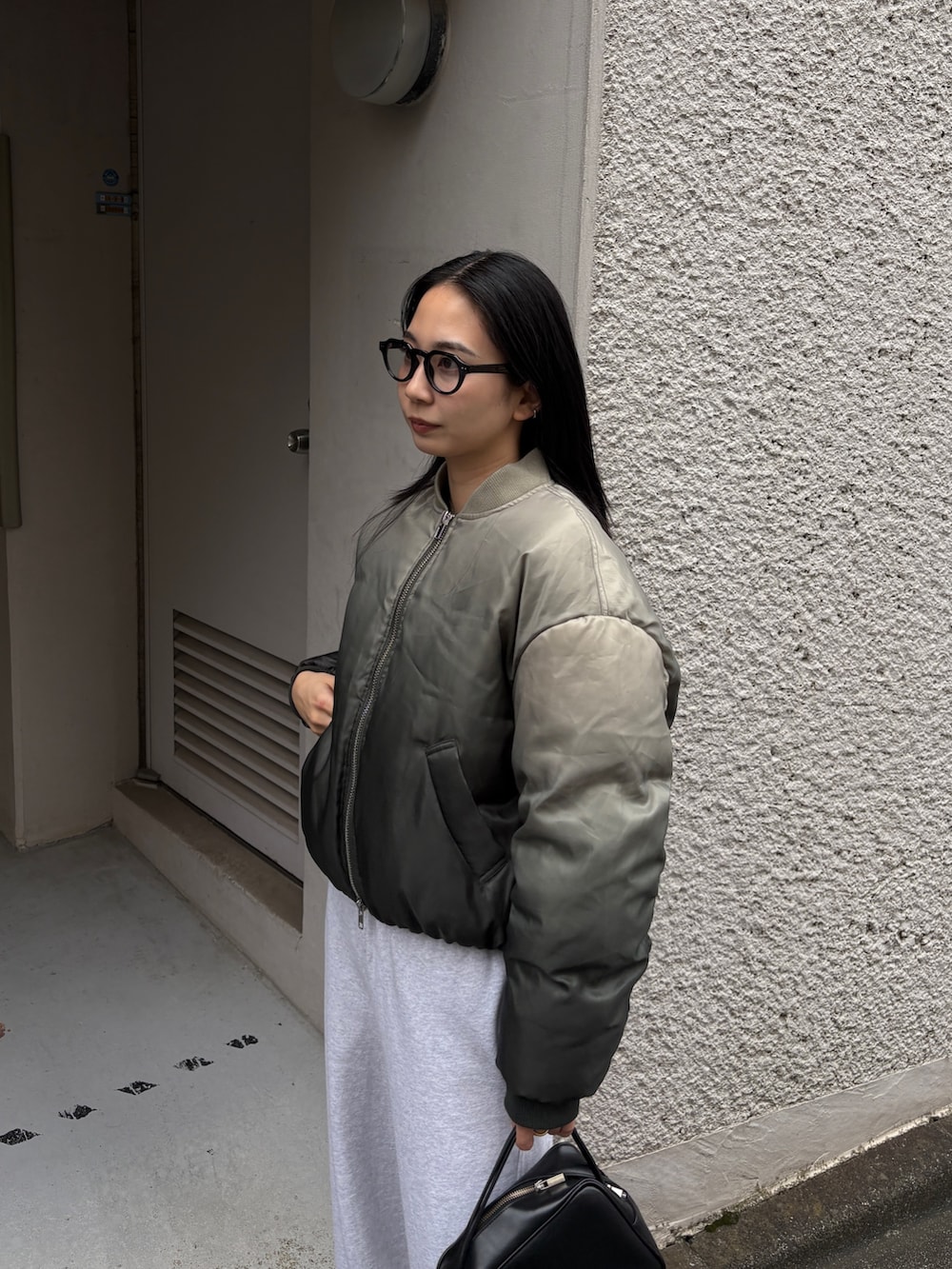 グレー系のスウェットパンツ、グリーン系のブルゾンを着用したレディースの冬コーディネートの4枚目の写真