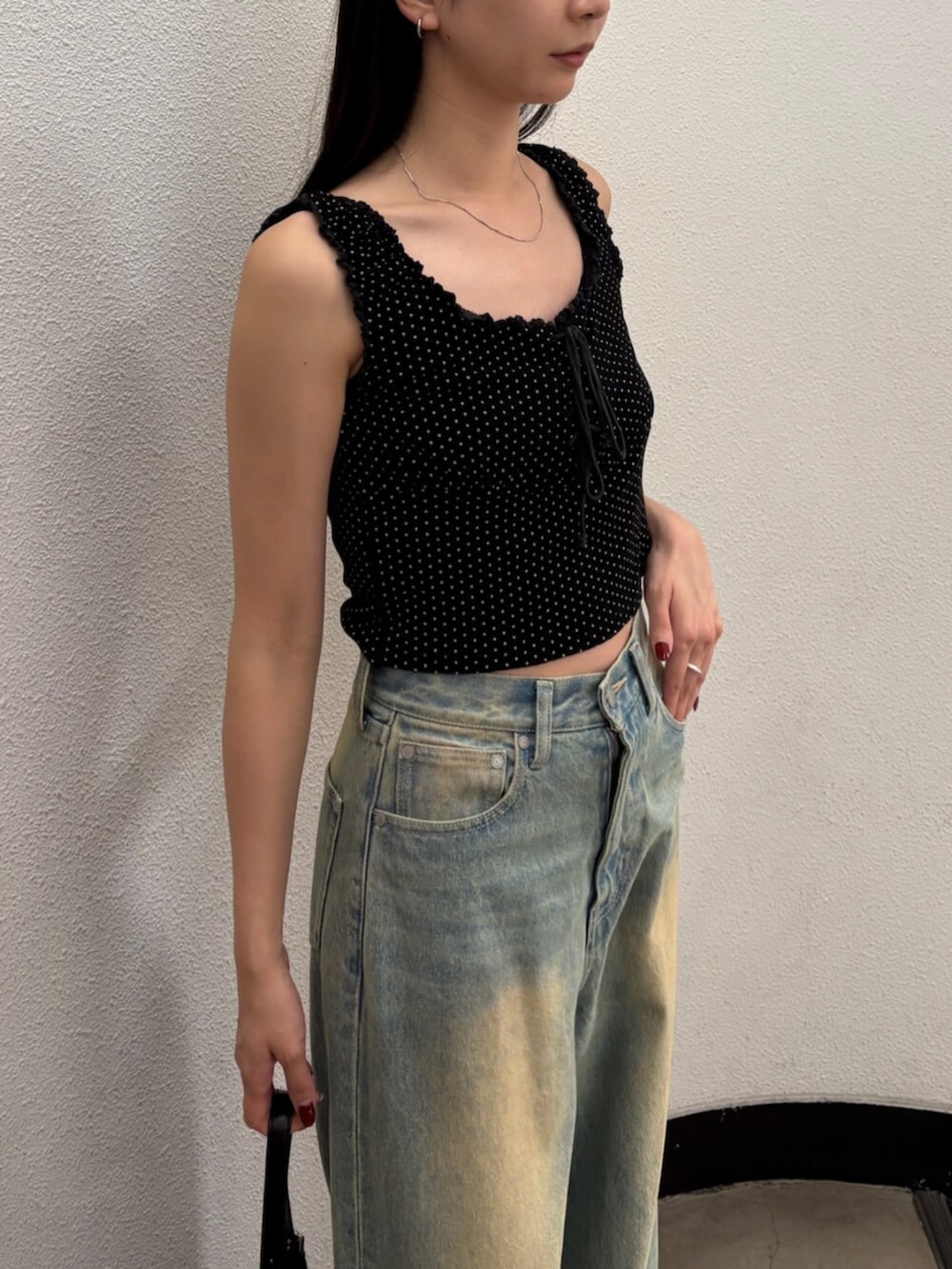 ブルー系のデニムパンツ、ブラック系のハンドバッグ、ブラック系のサンダルを着用したレディースの夏コーディネートの8枚目の写真