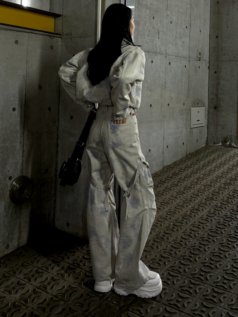 ホワイト系のデニムジャケット、ホワイト系のデニムパンツ、ホワイト系のスニーカーを着用したレディースの冬コーディネートの2枚目の写真