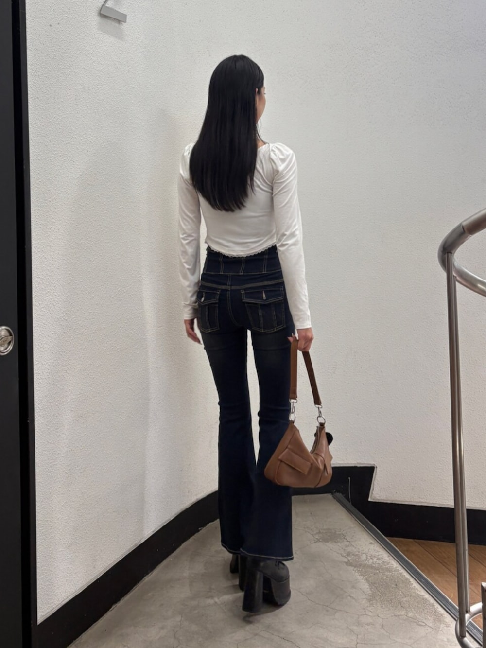 ブラック系のローファー、ホワイト系のTシャツ/カットソー、ブルー系のデニムパンツを着用したレディースの秋コーディネートの3枚目の写真