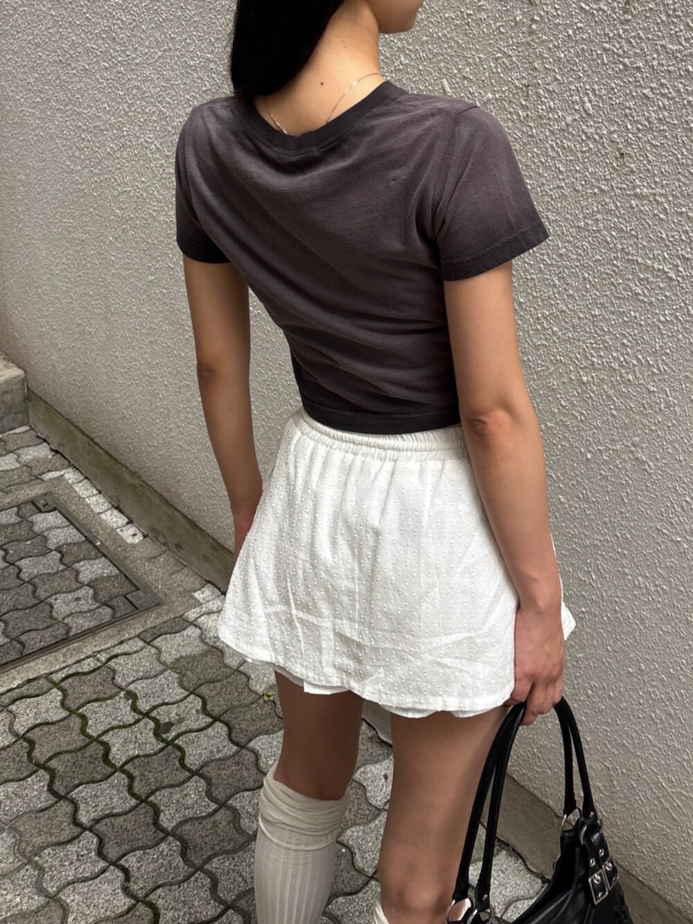 ブラック系のショルダーバッグ、ブラック系のサンダル、ブラック系のTシャツ/カットソーを着用したレディースの夏コーディネートの5枚目の写真