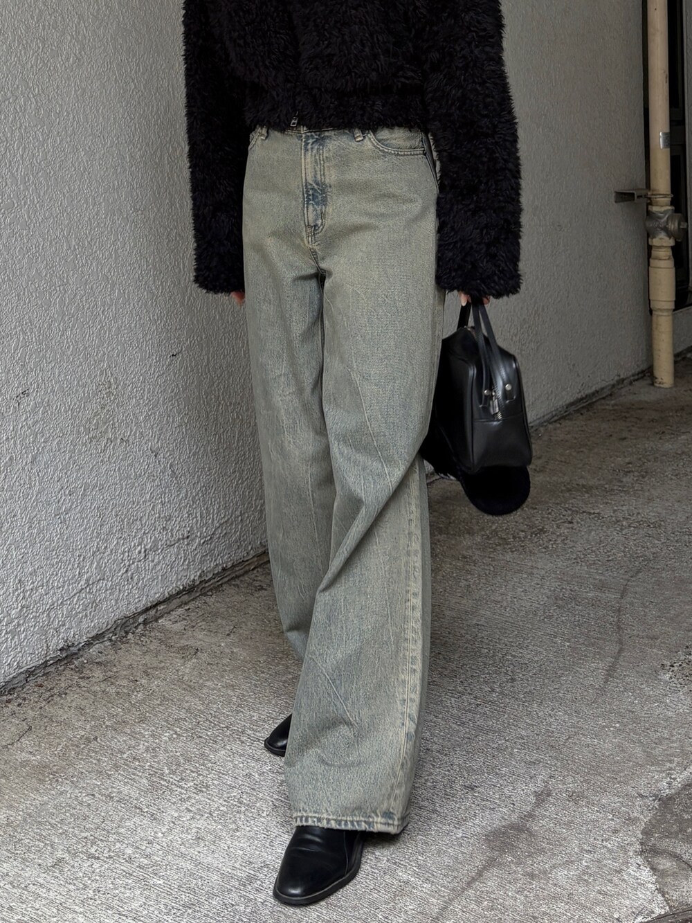 ブルー系のデニムパンツ、ブラック系のブルゾンを着用したレディースの冬コーディネートの3枚目の写真