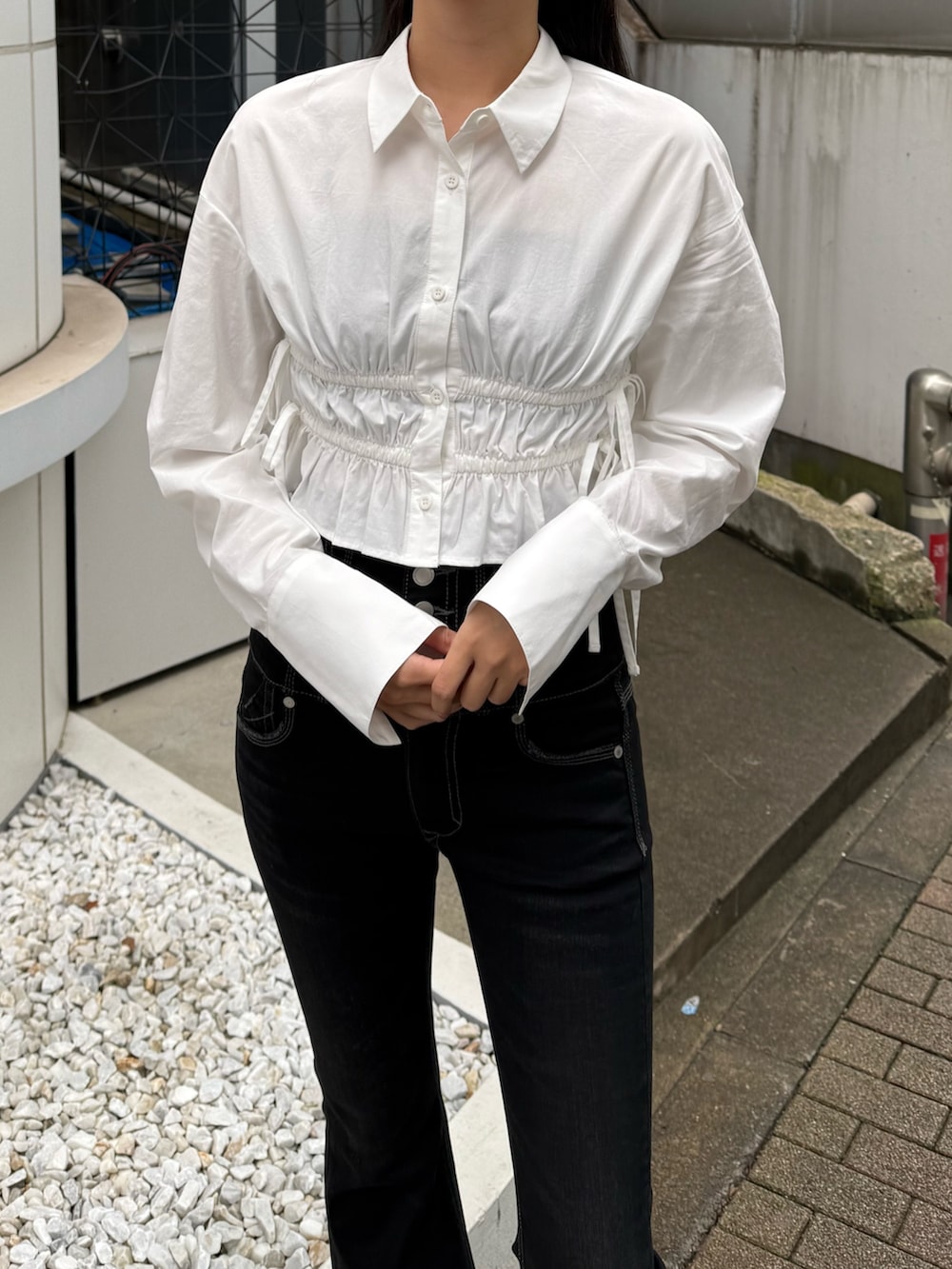 ブラック系のデニムパンツ、ホワイト系のシャツ/ブラウス、ブラック系のサンダルを着用したレディースの冬コーディネートの4枚目の写真