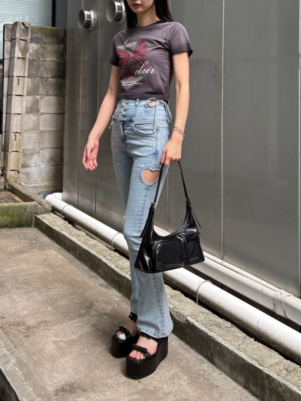 ブラック系のサンダル、ブラック系のTシャツ/カットソー、ブルー系のデニムパンツを着用したレディースの夏コーディネートの2枚目の写真