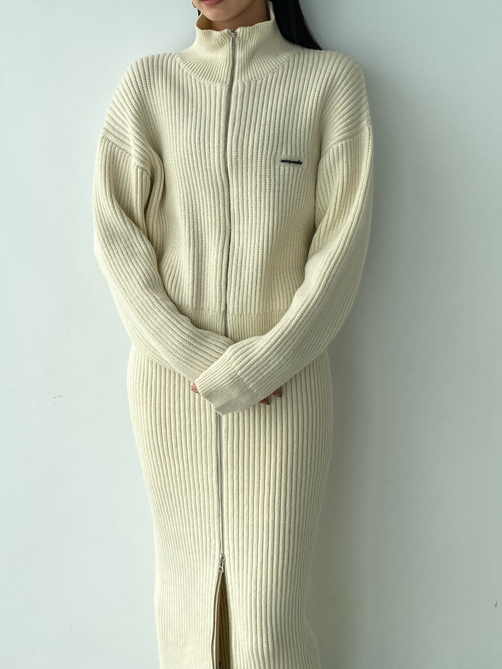 ホワイト系のニット/セーター、ホワイト系のスカート、ブラック系のブーツを着用したレディースの秋コーディネートの3枚目の写真