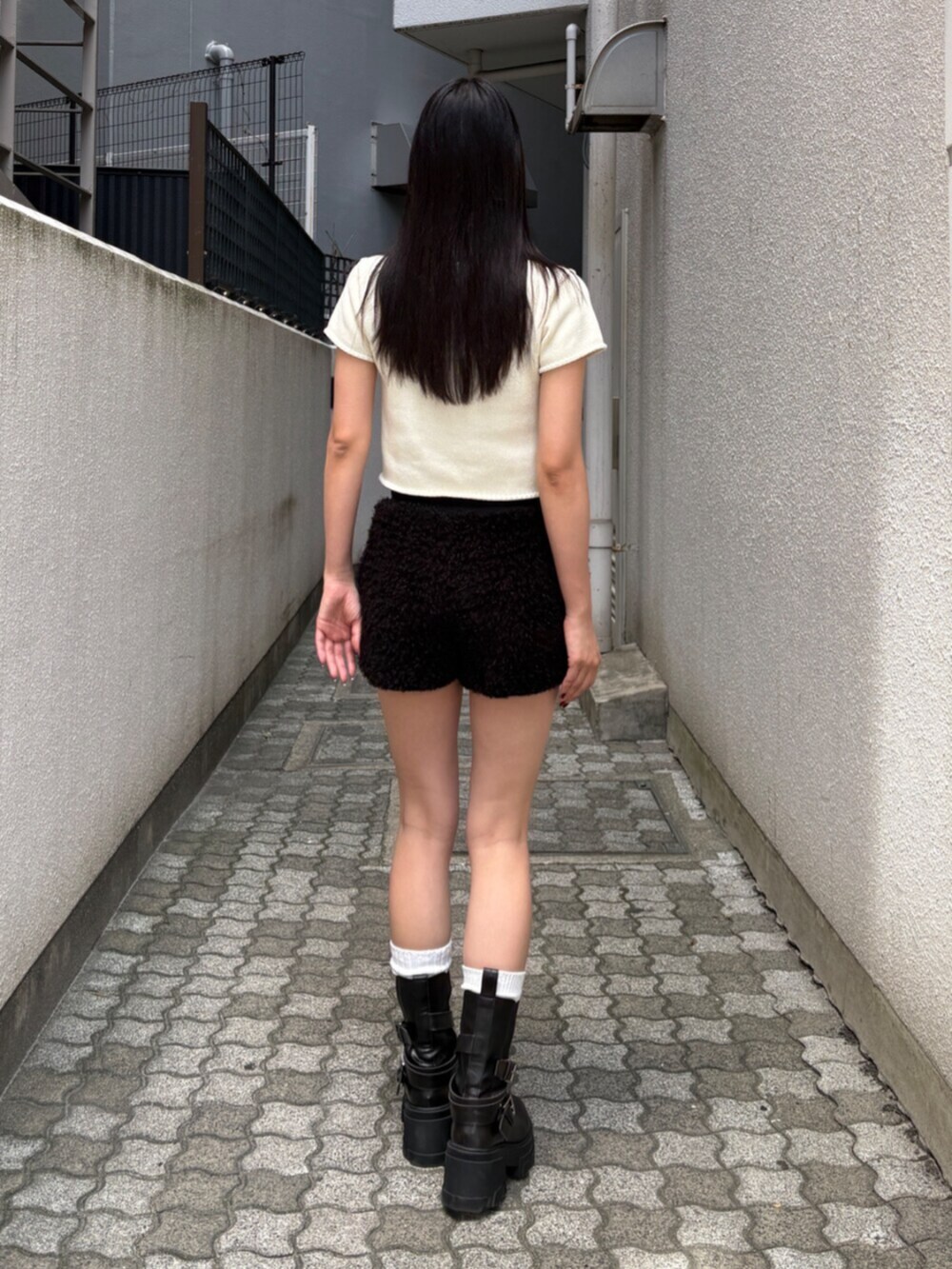 ブラック系のその他パンツ、ブラック系のブーツ、ホワイト系のニット/セーターを着用したレディースの夏コーディネートの3枚目の写真